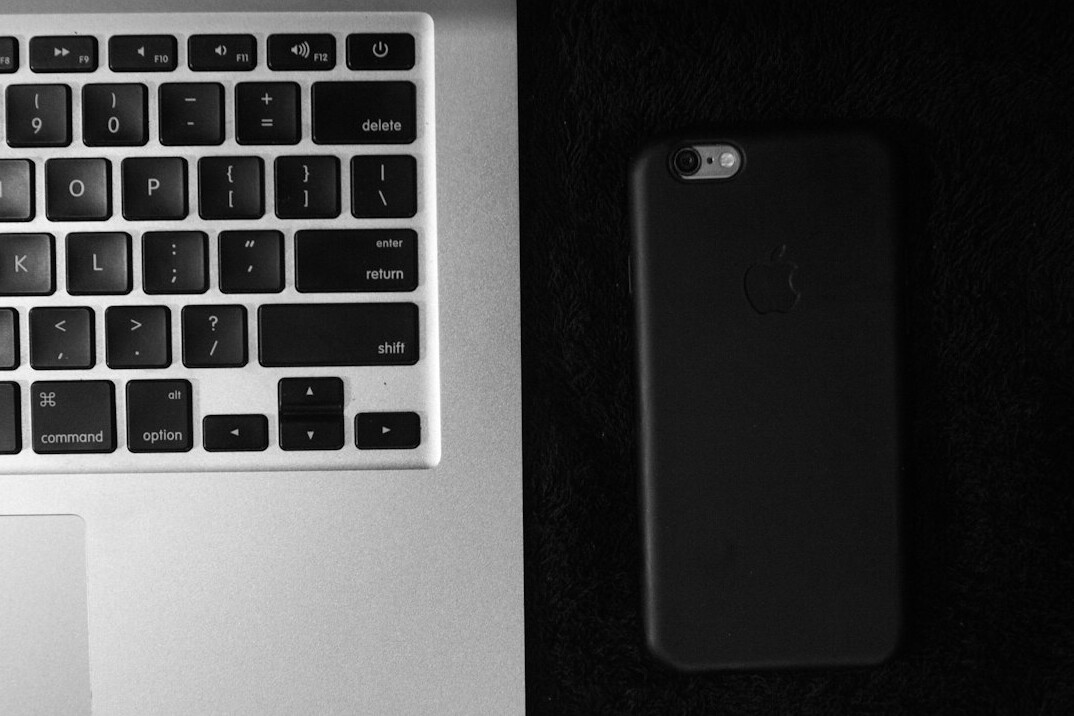 Desk with a laptop, notebook and phone ready for communication